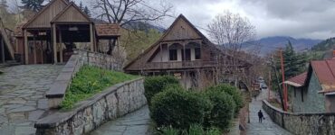 Dilijan old town cobbled street with traditional Armenian stone houses and forest hills behind