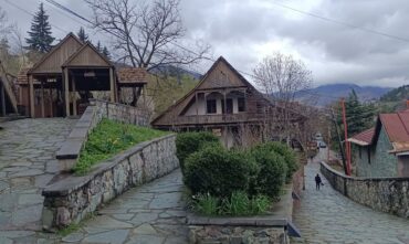 Dilijan old town cobbled street with traditional Armenian stone houses and forest hills behind