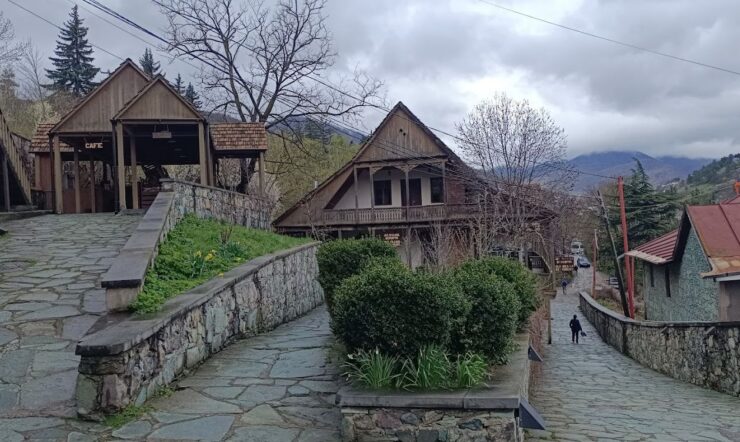 Dilijan old town cobbled street with traditional Armenian stone houses and forest hills behind
